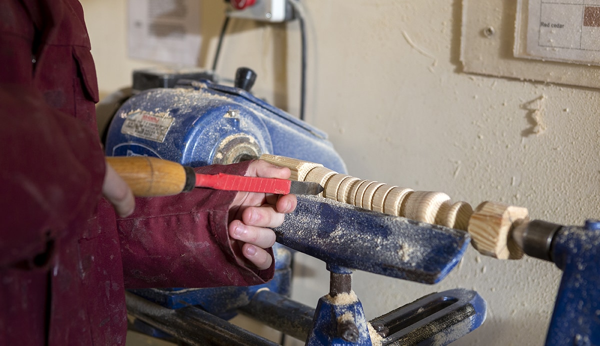 Student being instructed on the use of a woodworking lathe